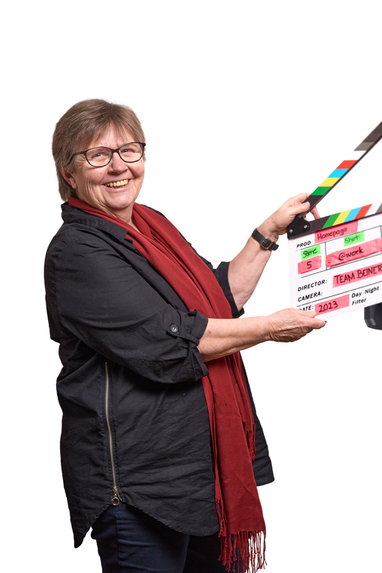 Seniorchefin Inge schlägt eine Filmklappe.